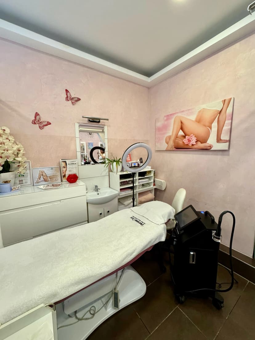 Treatment room with a professional skincare device, decorated in soft pink tones